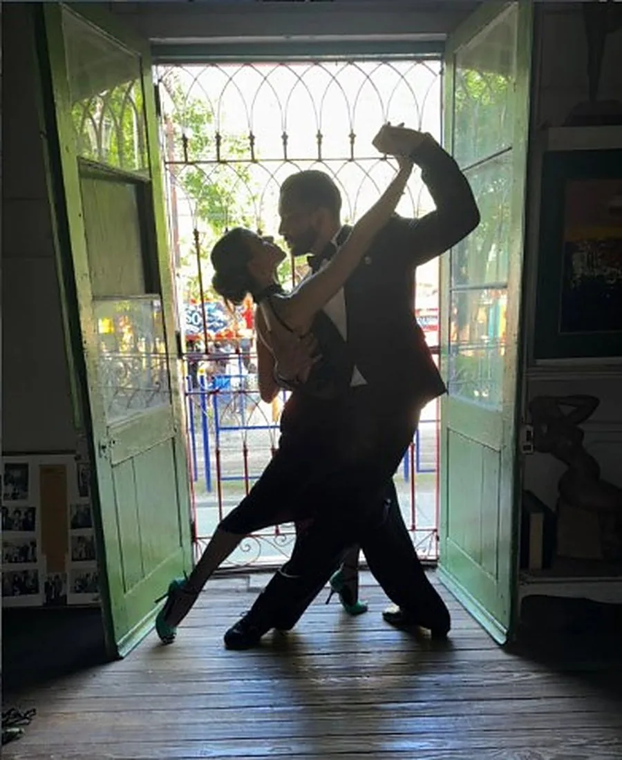 Pareja bailando tango en la puerta de la casa