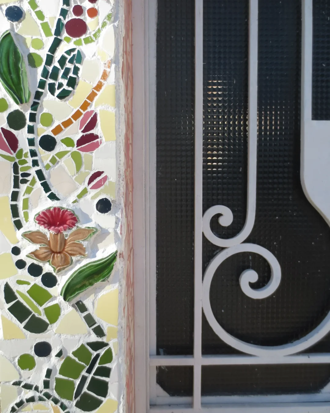 Detalle del mural: reja y flores en trencadís